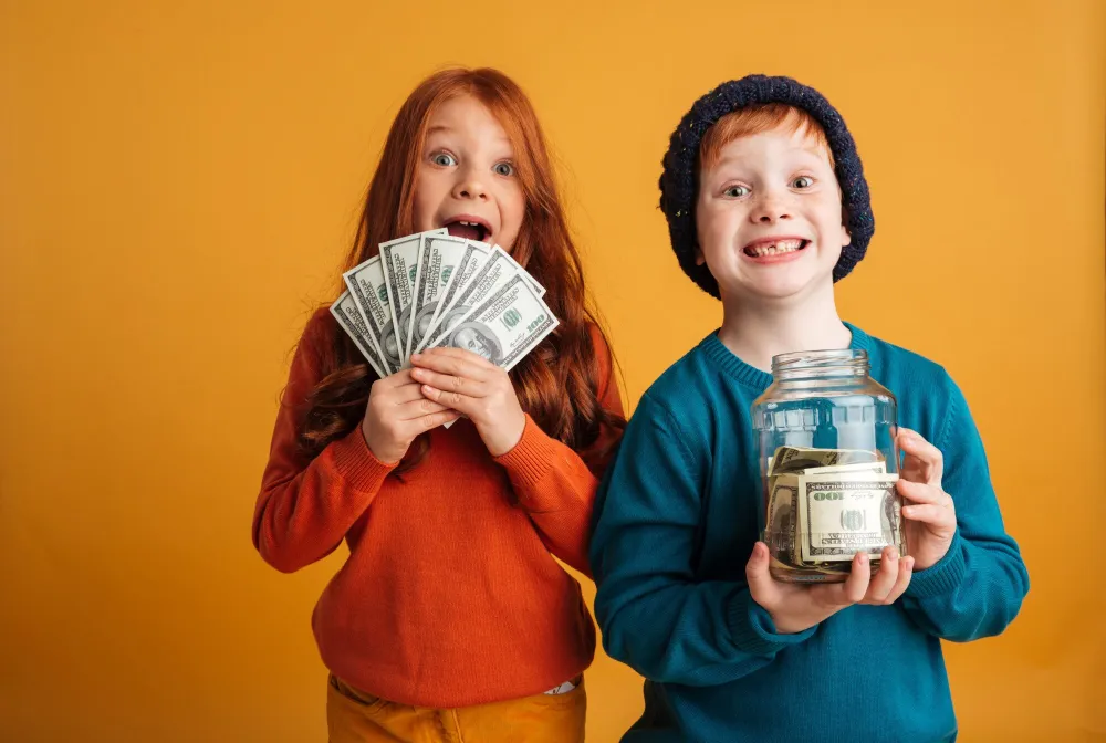 excited-little-redhead-children-holding-money_171337-1657